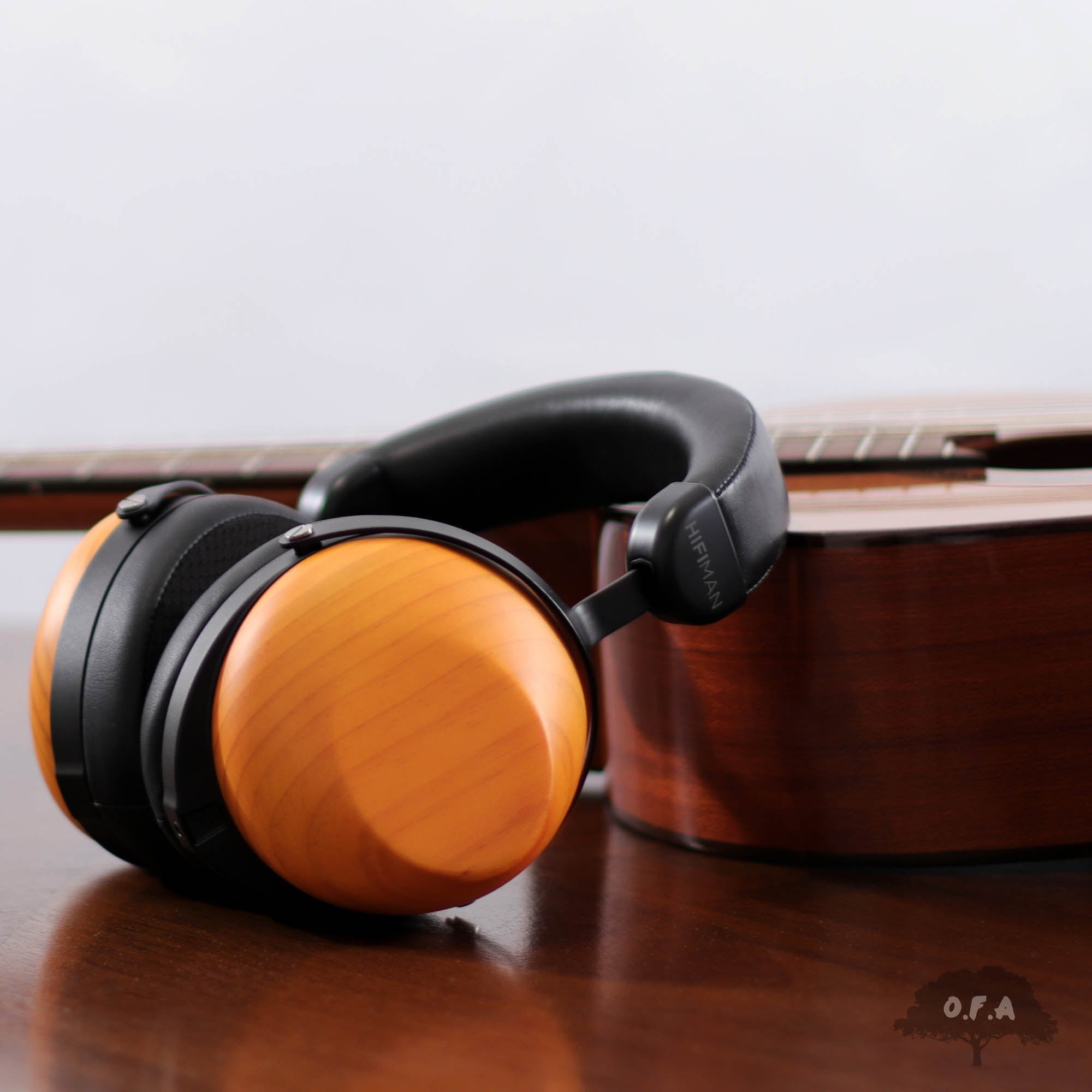 HIFIMAN HE-R10D Headphone leaning against a wood instrument
