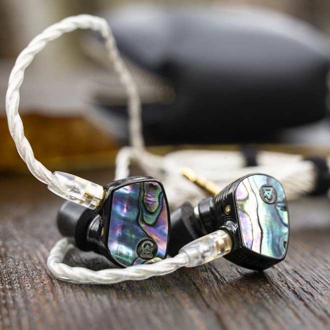Campfire Solaris Special Edition with radiant abalone lids and silver cable on wood surface
