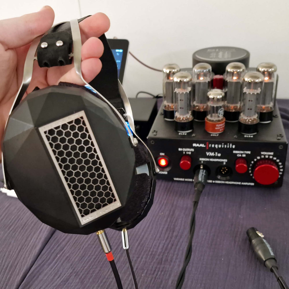 RAAL circumaural headphones held above a VM-1a tube headphone amplifier
