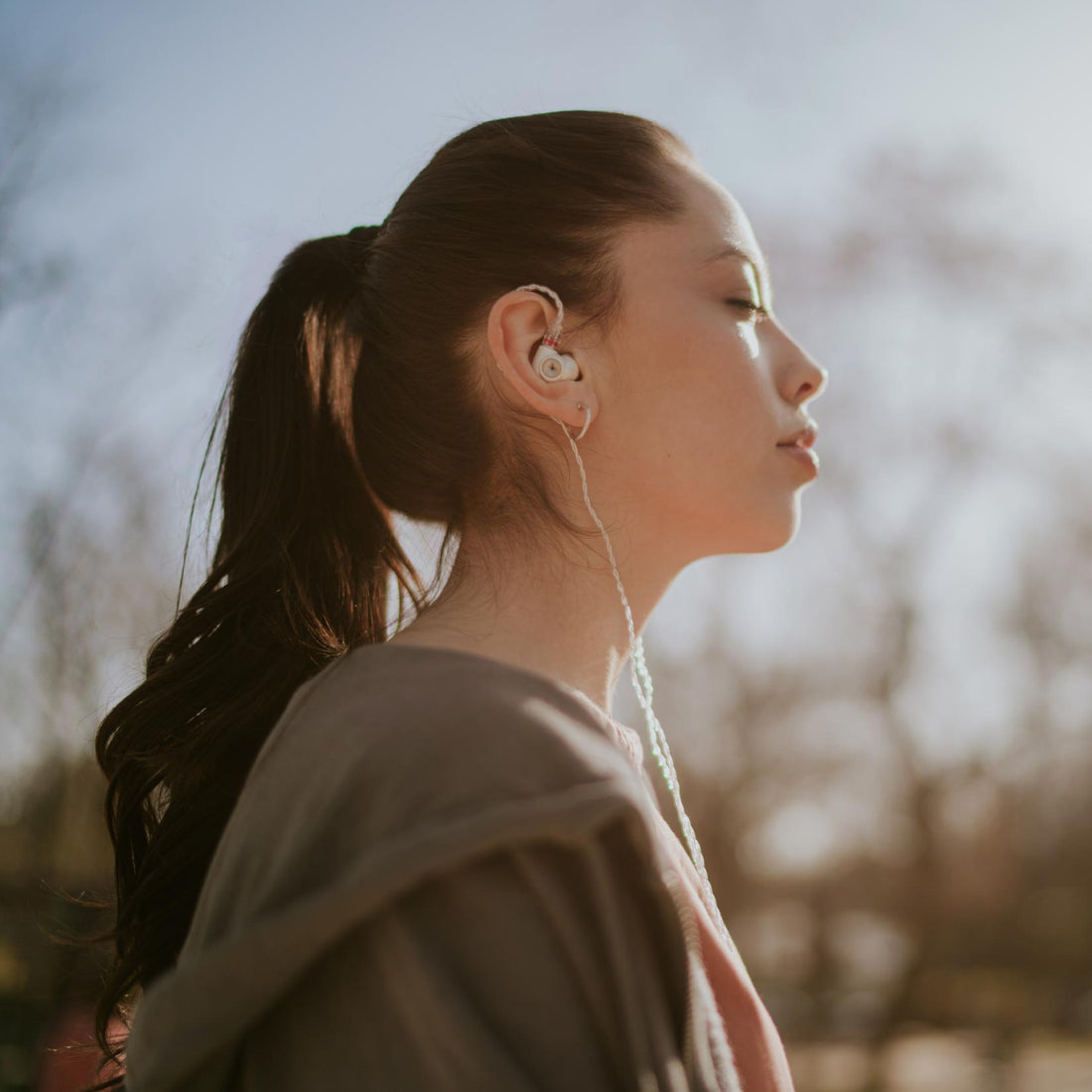 Woman enjoying the outdoors on brisk day wearing Meze Alba ear buds