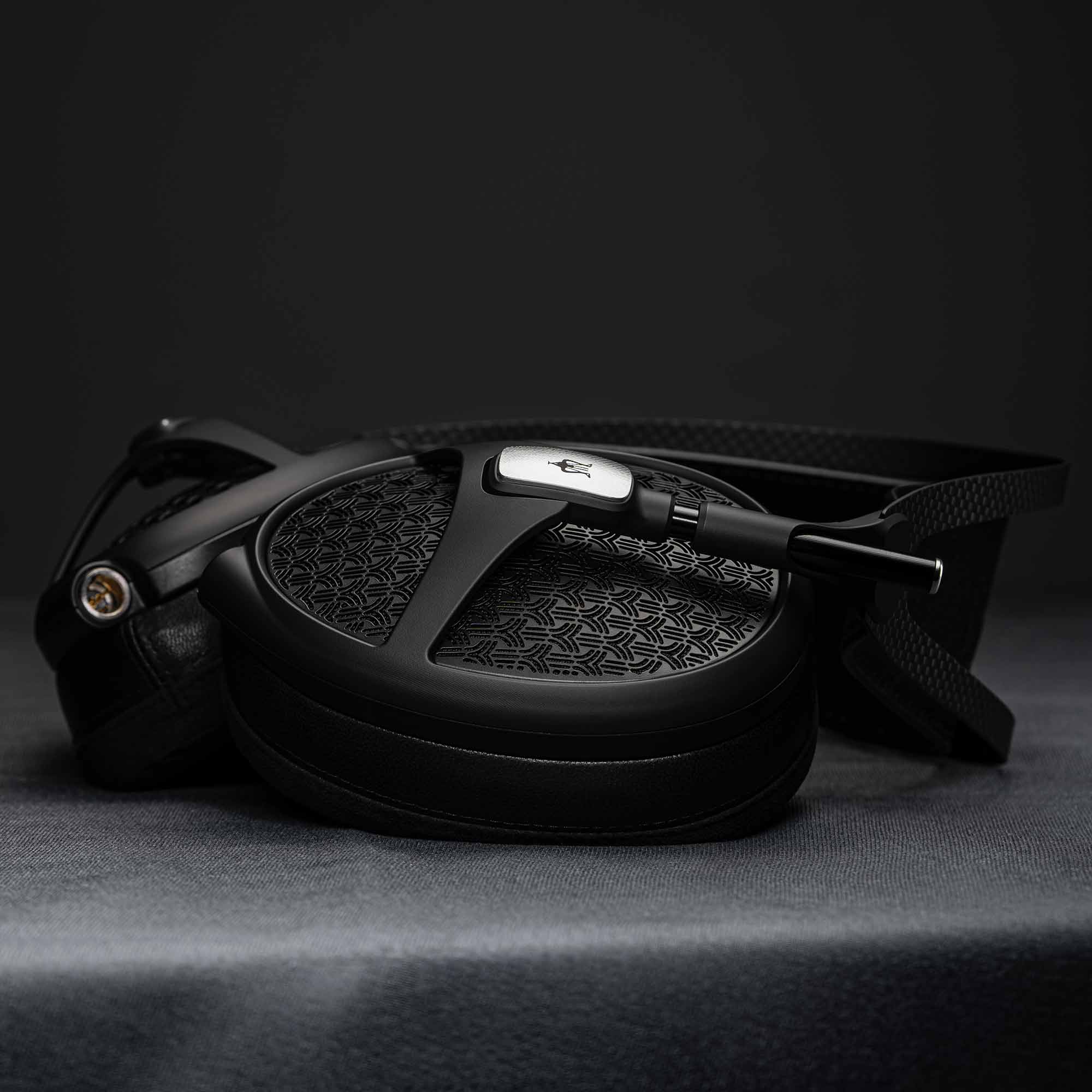 Meze Empyrean II headphone face down on dark table with dramatic lighting