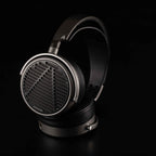 Audeze MM-100 open back planar magnetic headphones with metal frame and black leather ear pads on black background