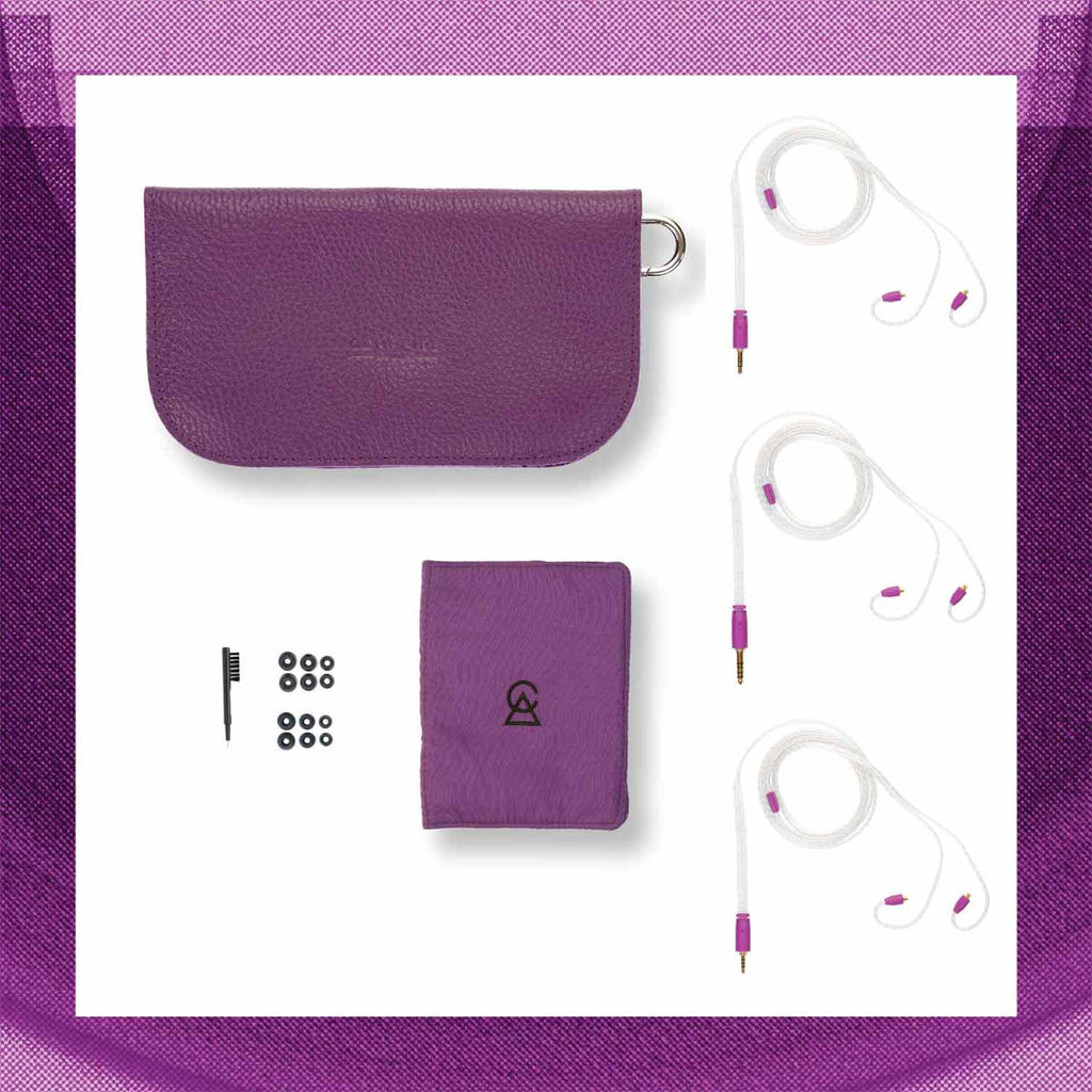 Flat lay of Campfire Bonneville earphones with purple carrying case, cleaning brush, and multiple ear tips on white background