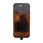 Campfire Audio Portable DAC Wallet attached to phone with brown leather and black elastic holder rings on white background