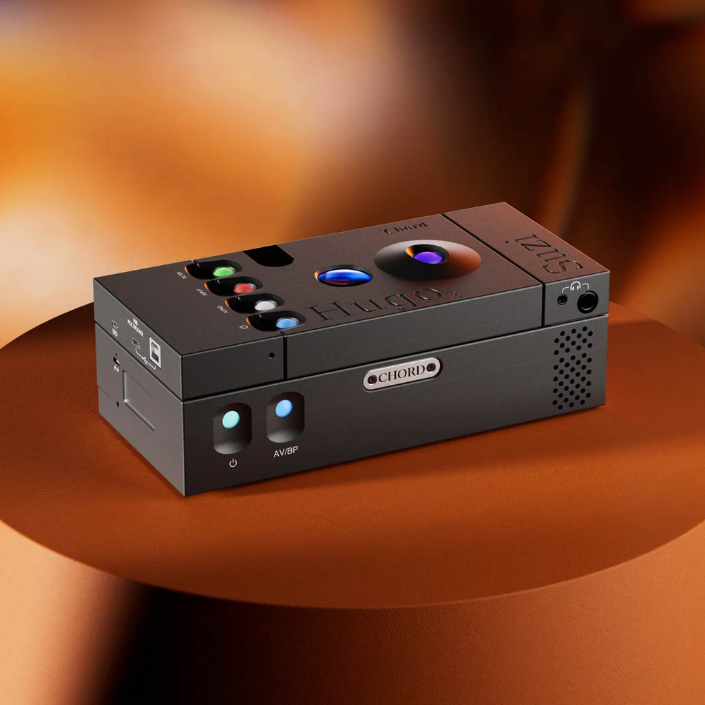 Chord Suzi Modular Stereo Power Amplifier with colorful control buttons and sleek black finish on curved brown surface