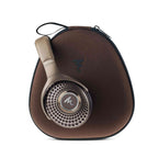 Focal Bathys MG Wireless Noise-Cancelling Headphones in brown resting on matching soft carrying case on white background