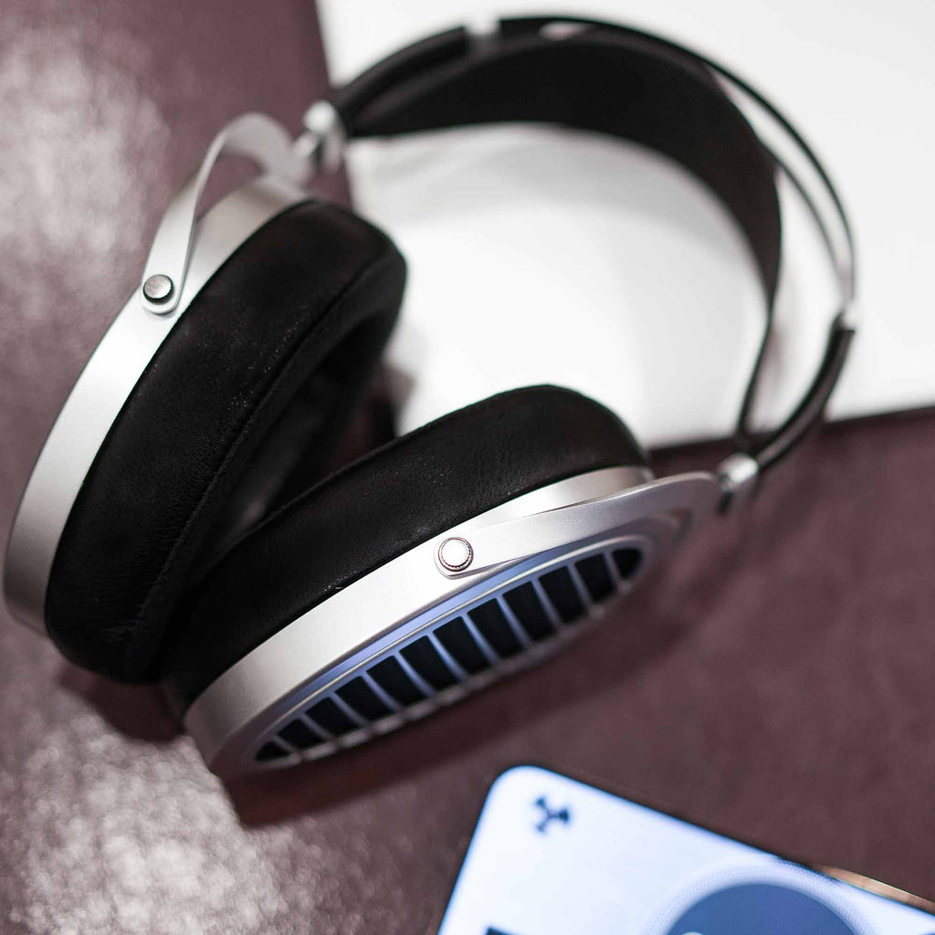 HIFIMAN Ananda | Nano open back headphones with silver frame and black ear pads resting on textured surface