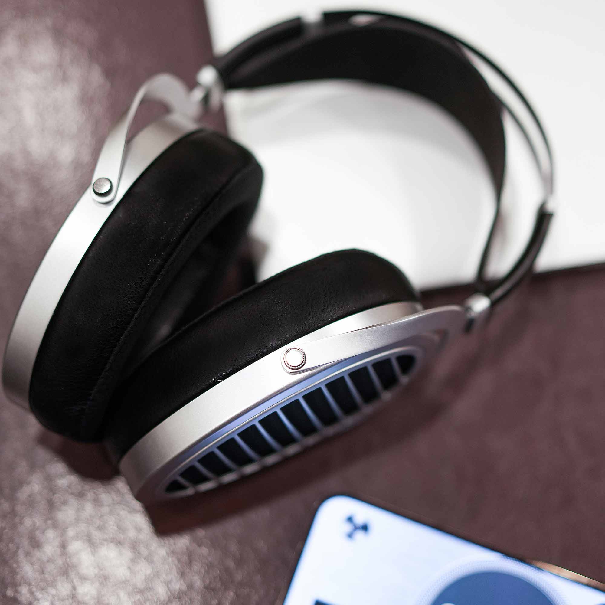 HIFIMAN Ananda | Nano open back headphones with silver frame and black ear pads resting on textured surface