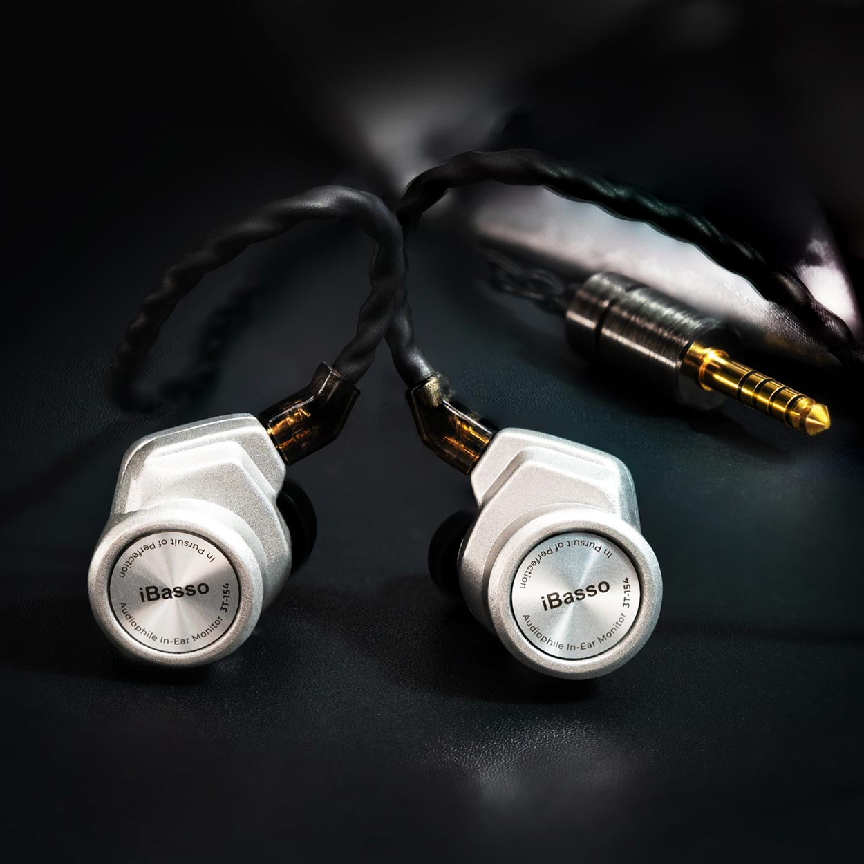 Close-up of iBasso 3T-154 Audiophile In-Ear Monitor with silver housings and braided cable on black surface