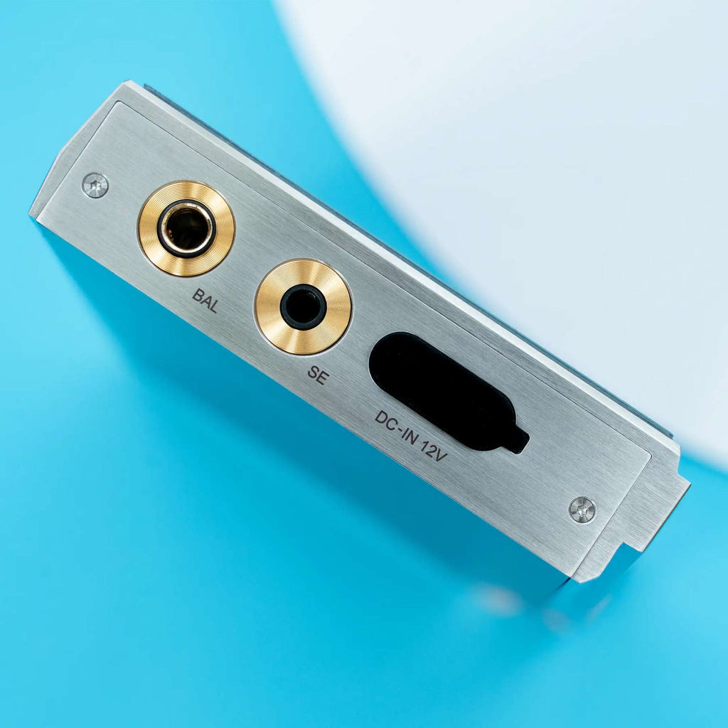 Close-up of the iBasso DX340 Flagship Digital Audio Player showing balanced and single-ended headphone jacks on a blue surface