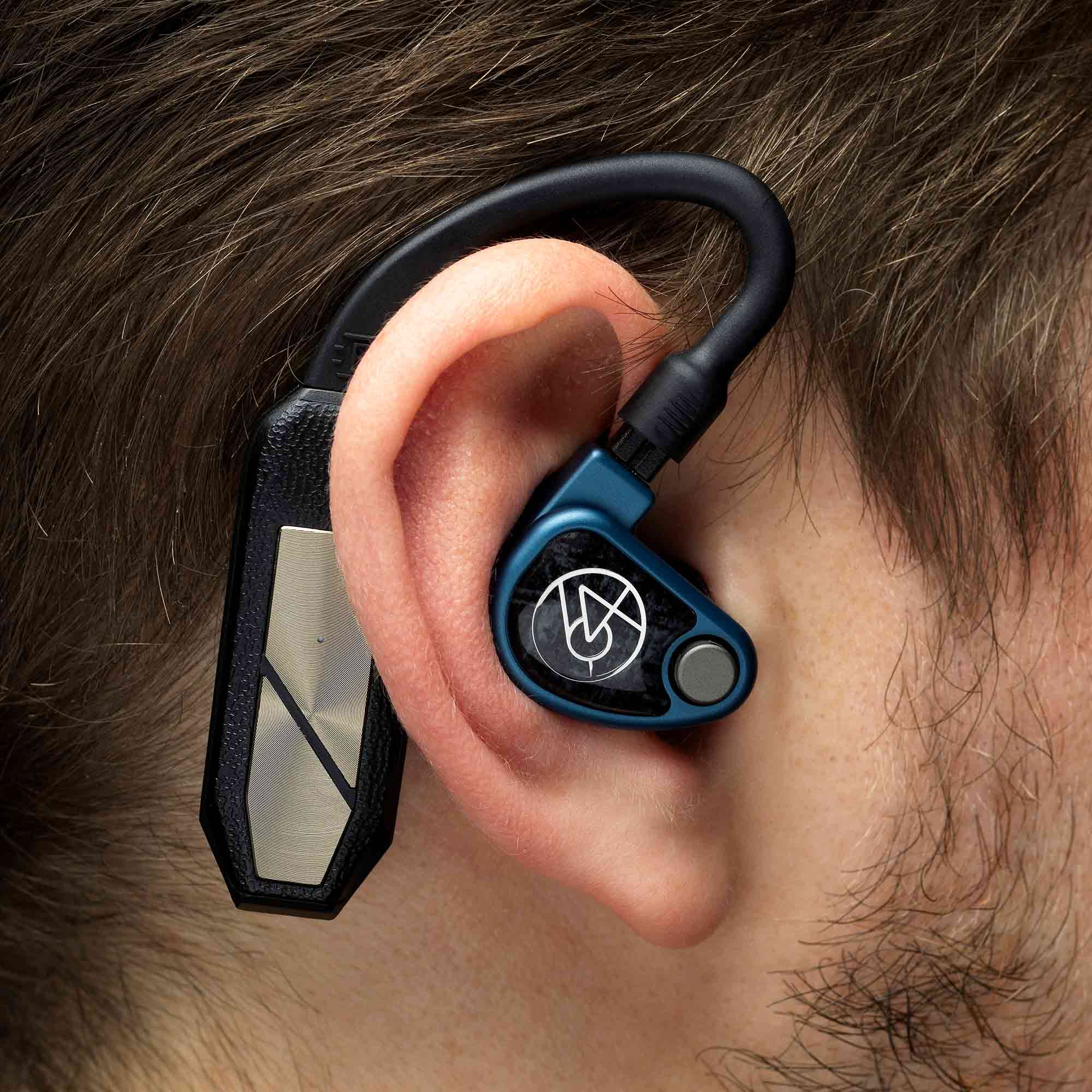 Close-up of iFi Audio GO Pod Wearable Bluetooth DAC/Amp attached behind the ear with in-ear monitor on person