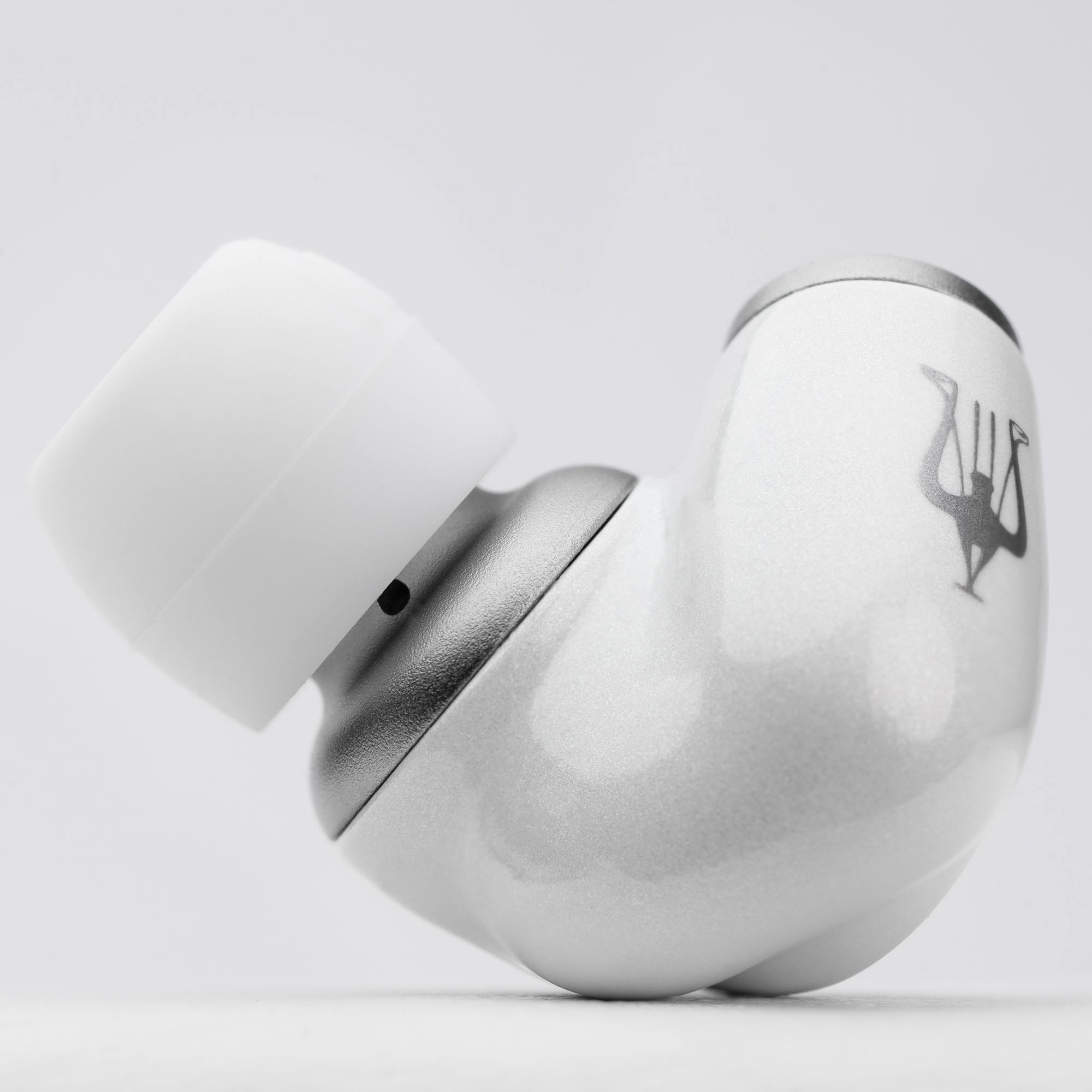 Close-up of a single white and silver Meze ALBA In-Ear Monitor earbud showing logo and silicone ear tip on white background