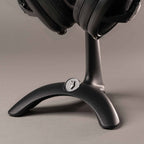 Close-up of the base of the Meze Manta Headphone Stand holding headphones with a dark matte finish and logo detail