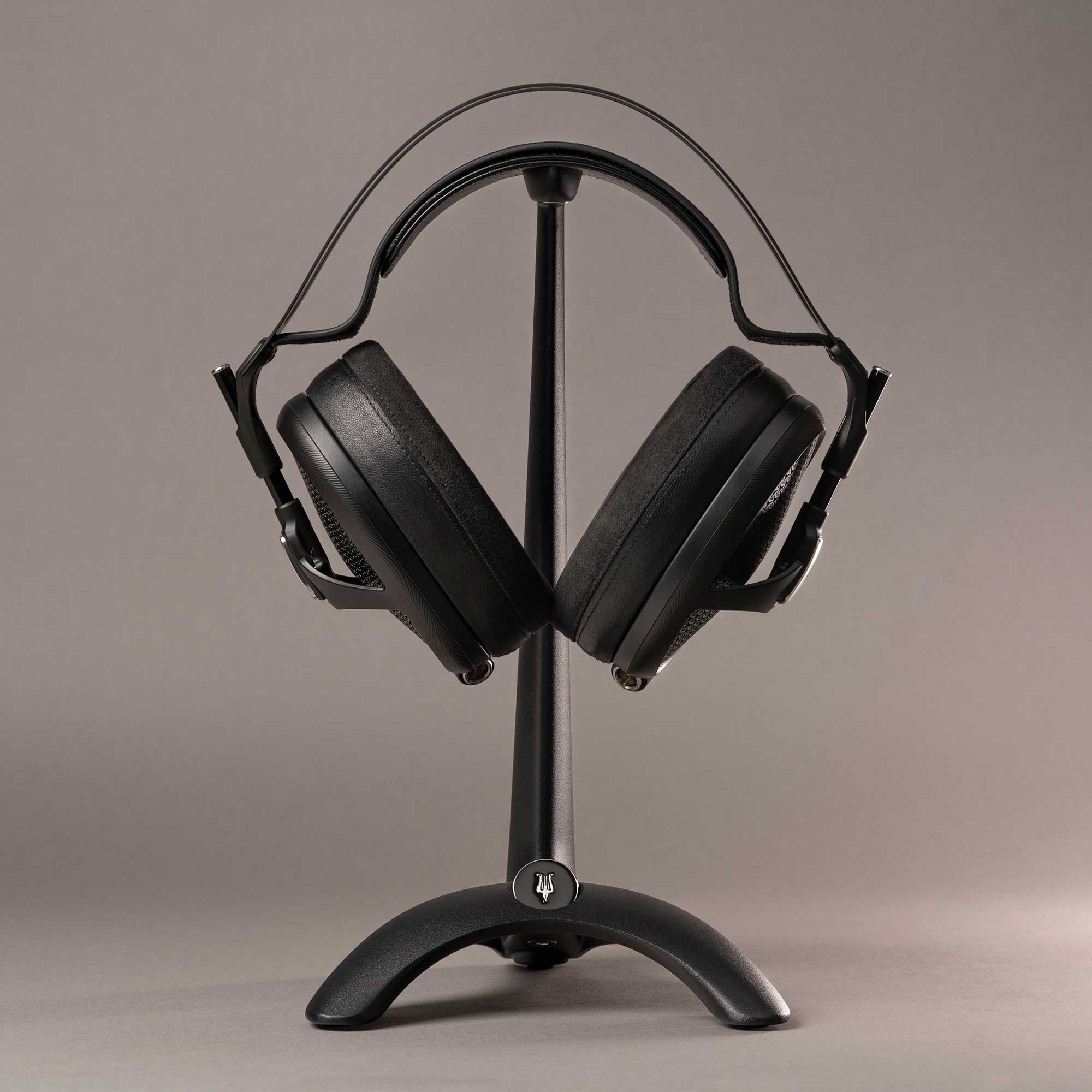 Meze Manta Headphone Stand holding black over-ear headphones on a plain neutral background