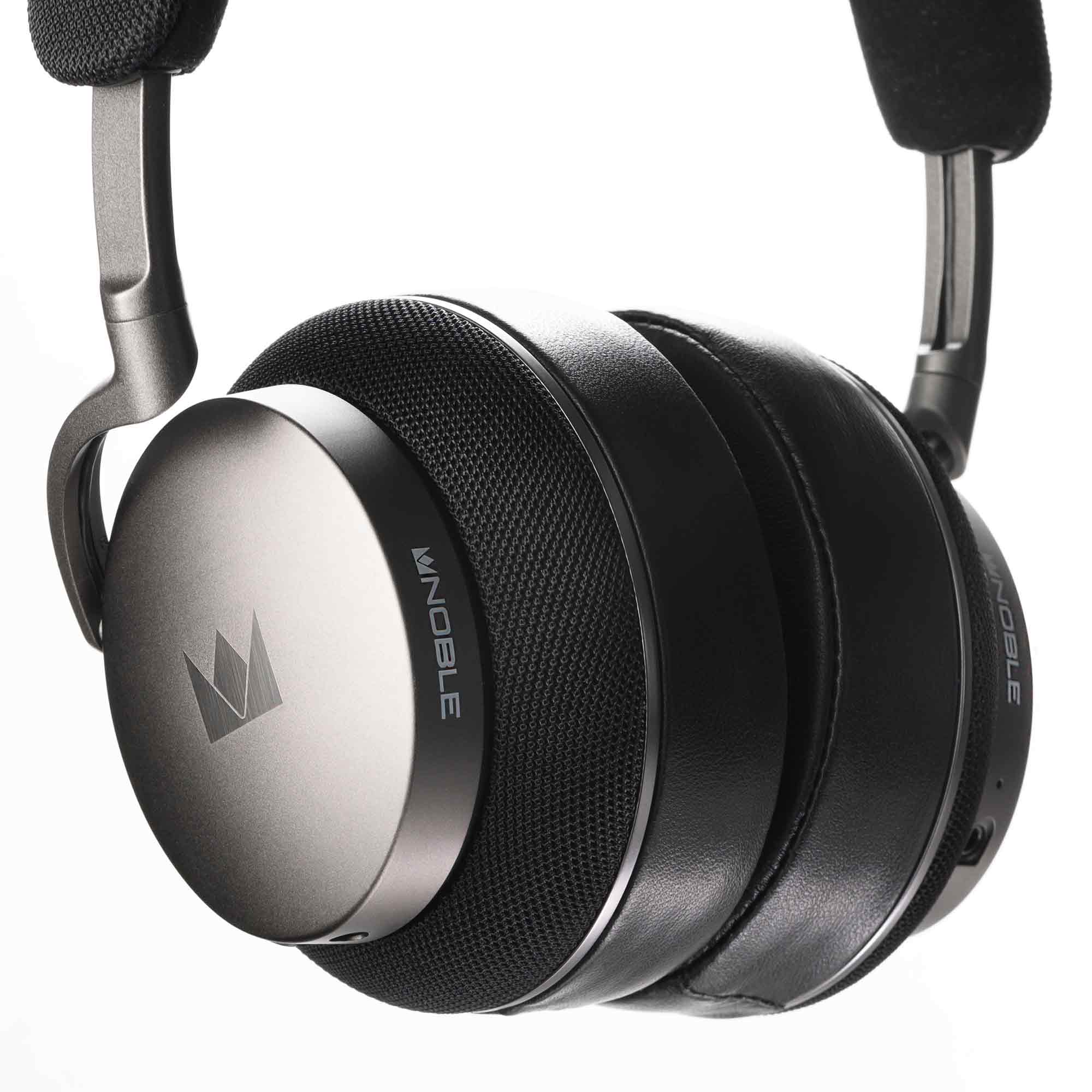 Close-up of Noble Audio FoKus Apollo Wireless Headphones showing metallic ear cups and cushioned headband on white background