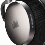 Close-up of the right ear cup on Noble Audio FoKus Apollo Wireless Headphones showing metal finish and logo detail