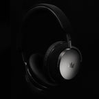 Noble Audio FoKus Apollo Wireless Headphones close-up showing silver ear cups and padded headband on black background