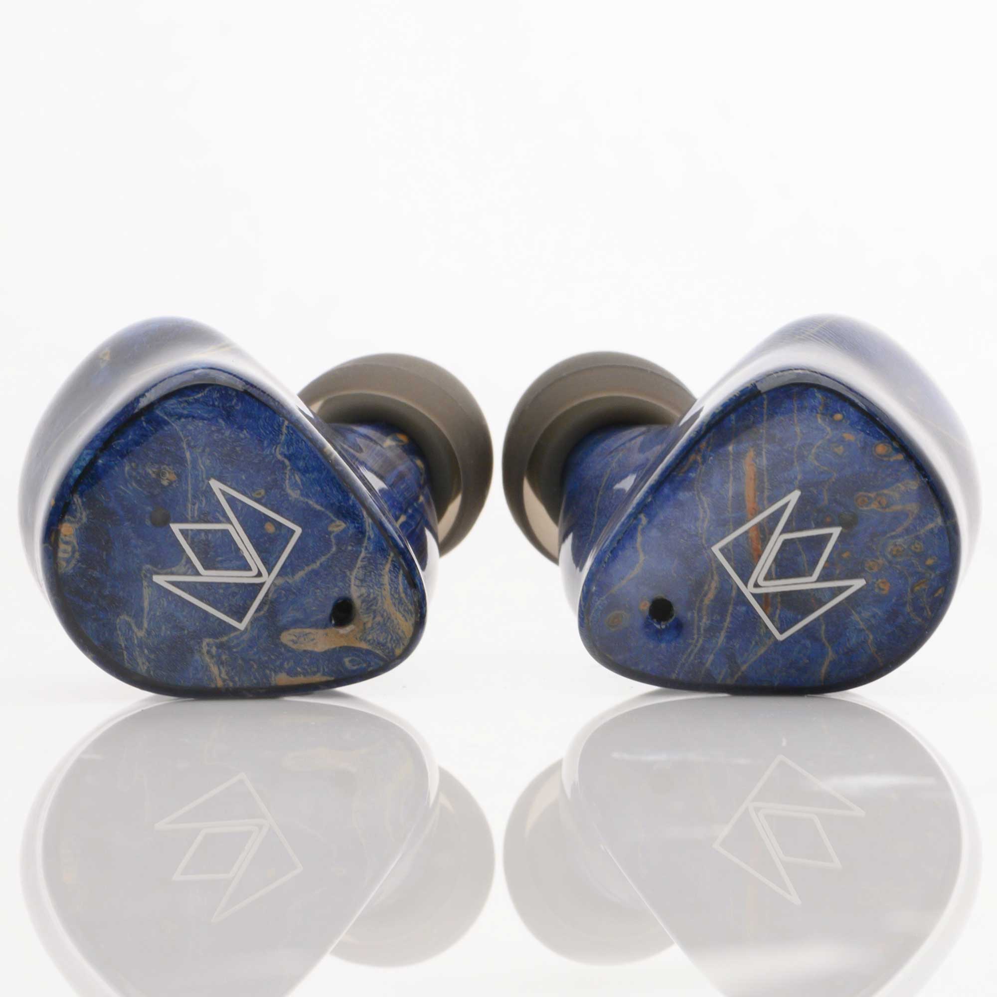 Noble Audio FoKus Prestige Wireless IEM in blue with sleek design and silver logo on reflective white surface