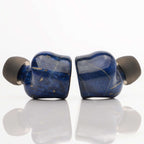 Noble Audio FoKus Prestige Wireless IEMs in deep blue with gold veining and black ear tips on white surface