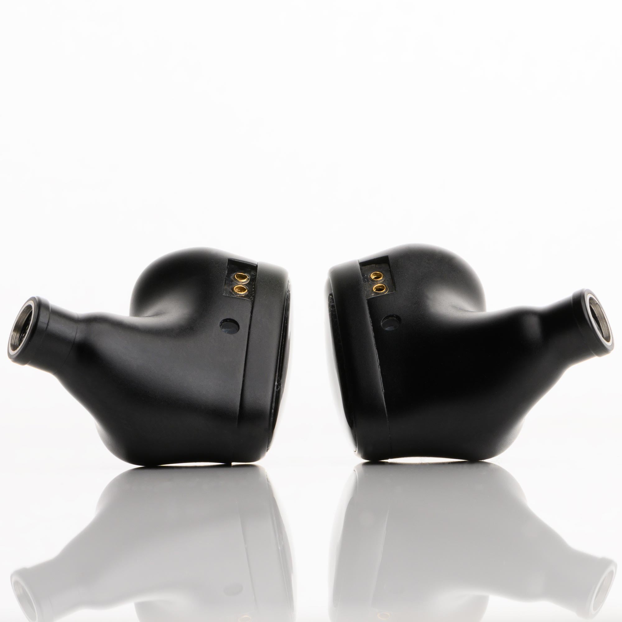 Pair of black Noble Audio Onyx Universal Fit In-Ear Monitors shown from side on reflective white surface