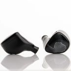 Noble Audio Onyx Universal Fit In-Ear Monitors in black with mesh grille on a reflective white surface close-up view