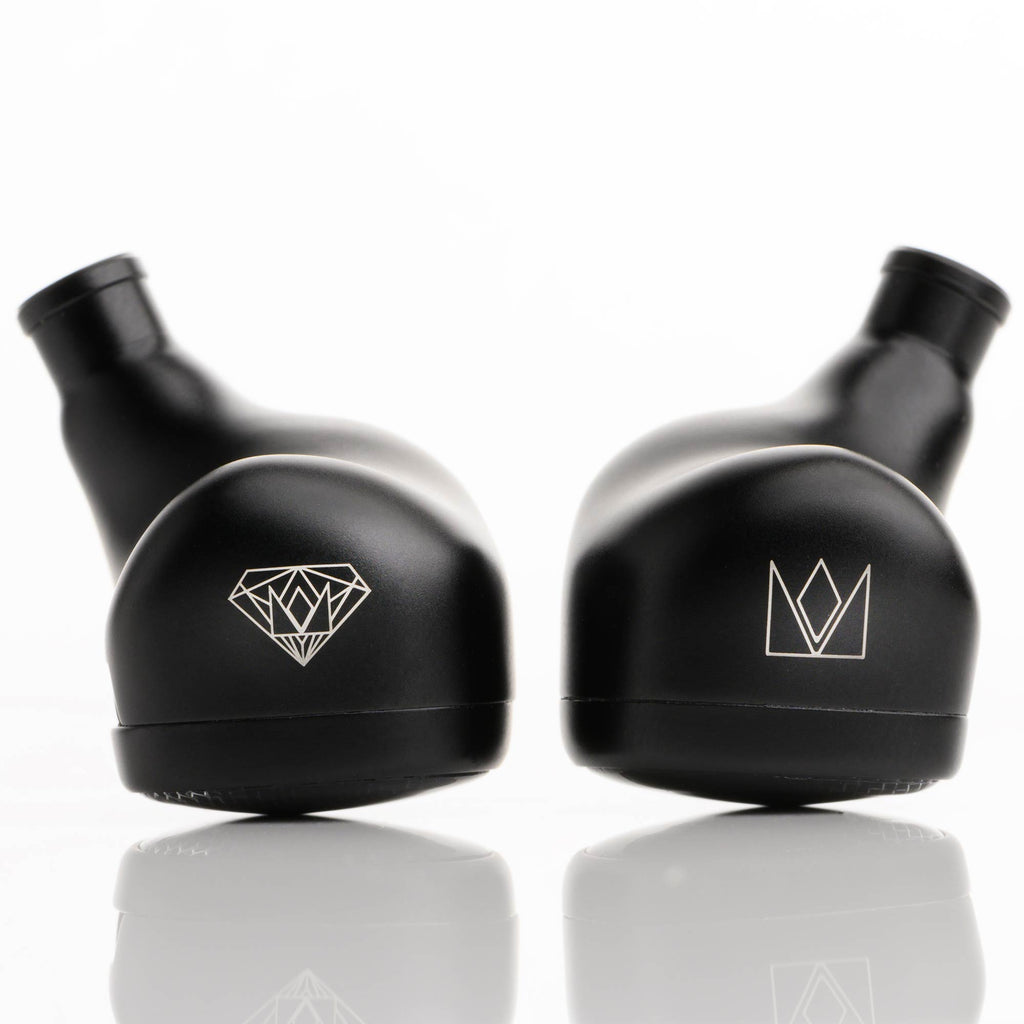 Close-up of black Noble Audio Onyx Universal Fit In-Ear Monitors resting on reflective surface with logos visible