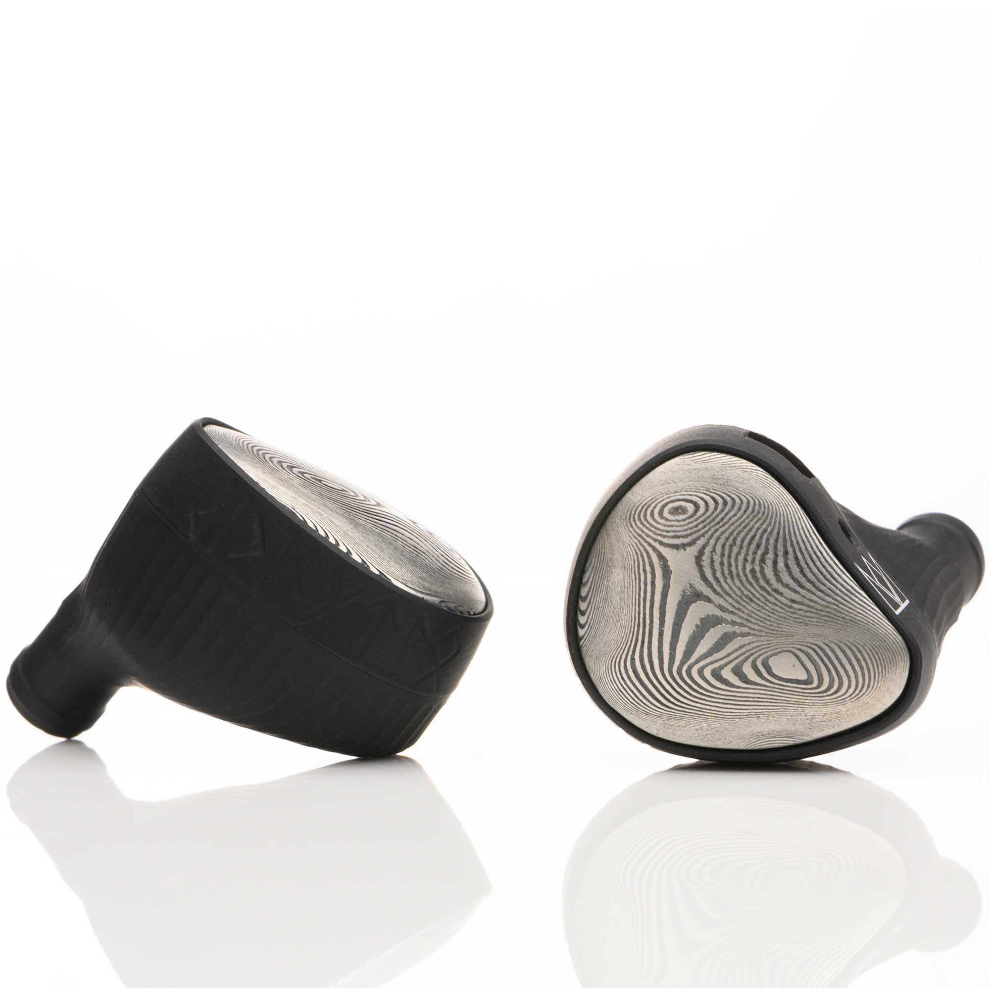 Close-up of Noble Audio Viking Ragnar Universal-Fit IEM with patterned faceplates on white reflective surface