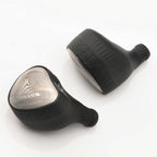 Pair of Noble Audio Viking Ragnar Universal-Fit IEM with textured black housings and patterned silver faceplates on white background