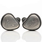 Pair of Noble Audio Viking Ragnar Universal-Fit IEM with textured metal faceplates resting on reflective white surface