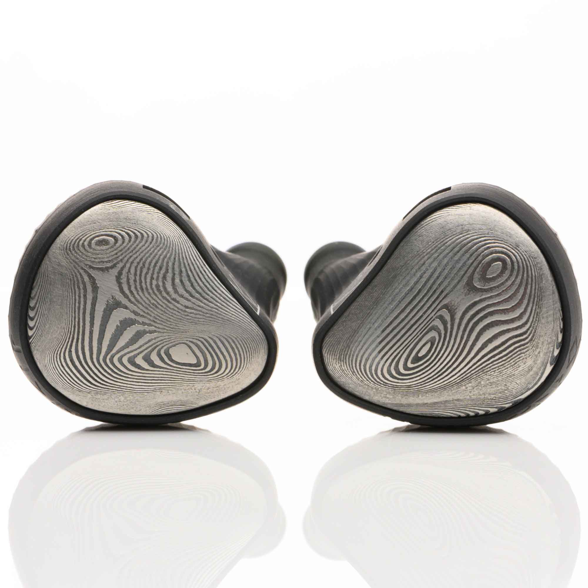 Pair of Noble Audio Viking Ragnar Universal-Fit IEM with textured metal faceplates resting on reflective white surface