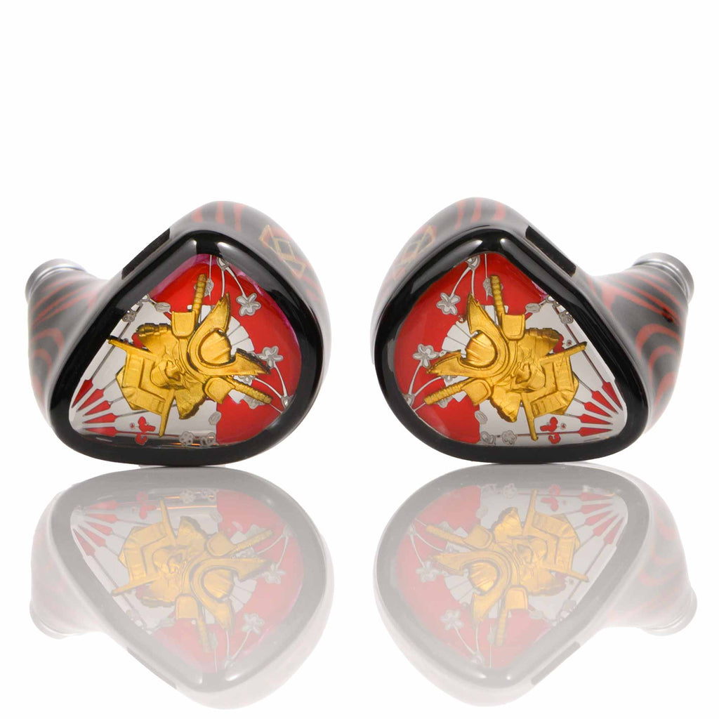 Noble Audio Shogun IEM with red, black, and gold artistic faceplate design shown on a reflective white surface