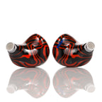 Noble Audio Shogun IEM with black and red swirling design and metal mesh nozzles on reflective white surface