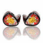 Pair of Noble Audio Shogun IEMs with red, gold, and black samurai-themed design on reflective surface