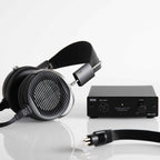 STAX SRS-X1000 Electrostatic Earspeaker System with black earcups and SRM-270S driver unit on reflective surface