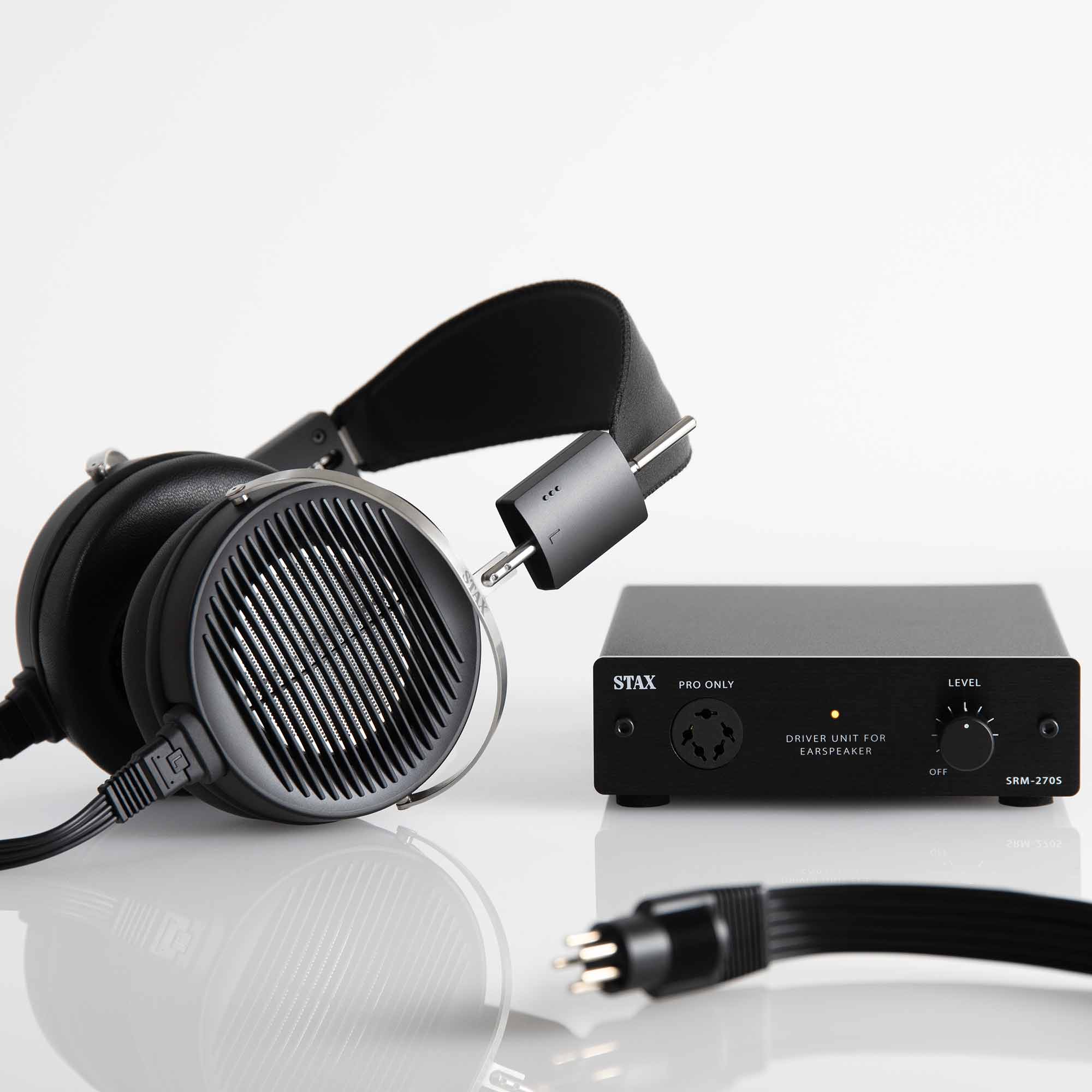 STAX SRS-X1000 Electrostatic Earspeaker System with black earcups and SRM-270S driver unit on reflective surface