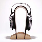 STAX SR-X9000 electrostatic headphones resting on a minimalist wooden headphone stand against a white background