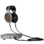 Warwick Acoustics BRAVURA Electrostatic Earspeaker System with open-back headphones connected to a silver amplifier on white background