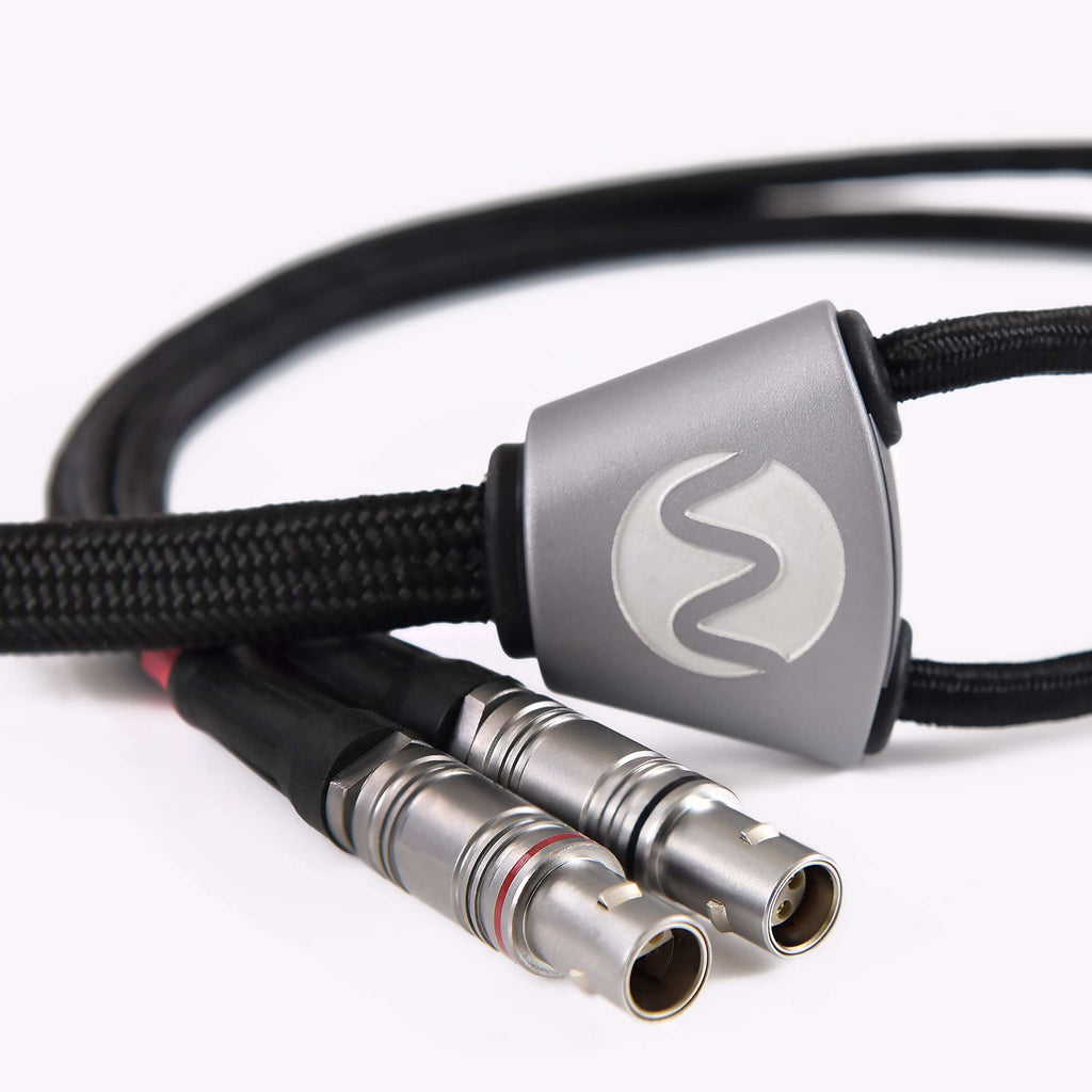 Close-up of Warwick Acoustics APERIO Electrostatic Earspeaker System silver connectors with braided cable on white background