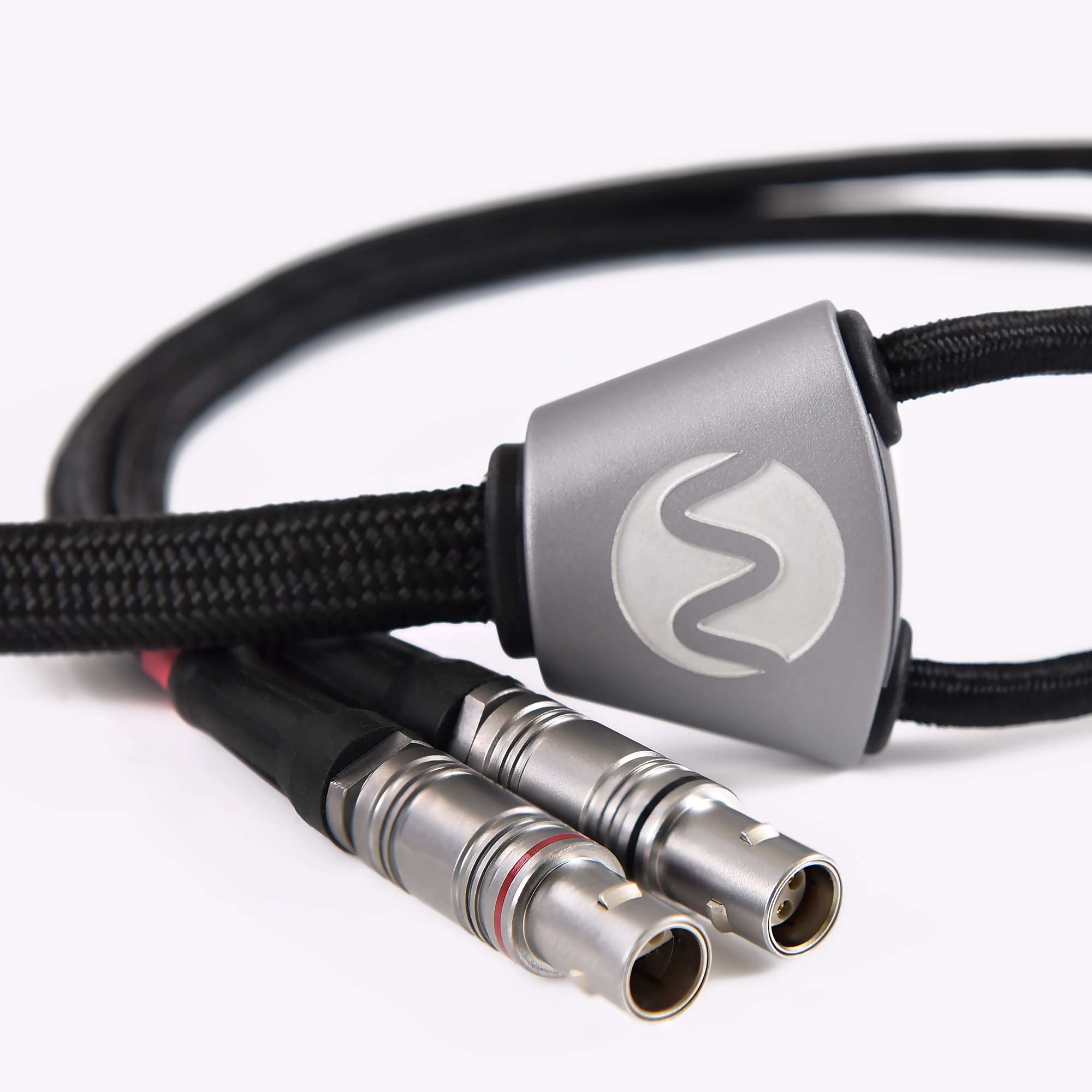 Close-up of Warwick Acoustics APERIO Electrostatic Earspeaker System silver connectors with braided cable on white background