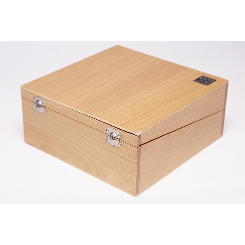 Closed wooden storage box with metal clasps containing the AKG K1000 headphones and accessories on white background
