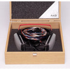 AKG K1000 headphones with original wooden storage box and coiled multicolor cable inside on white background