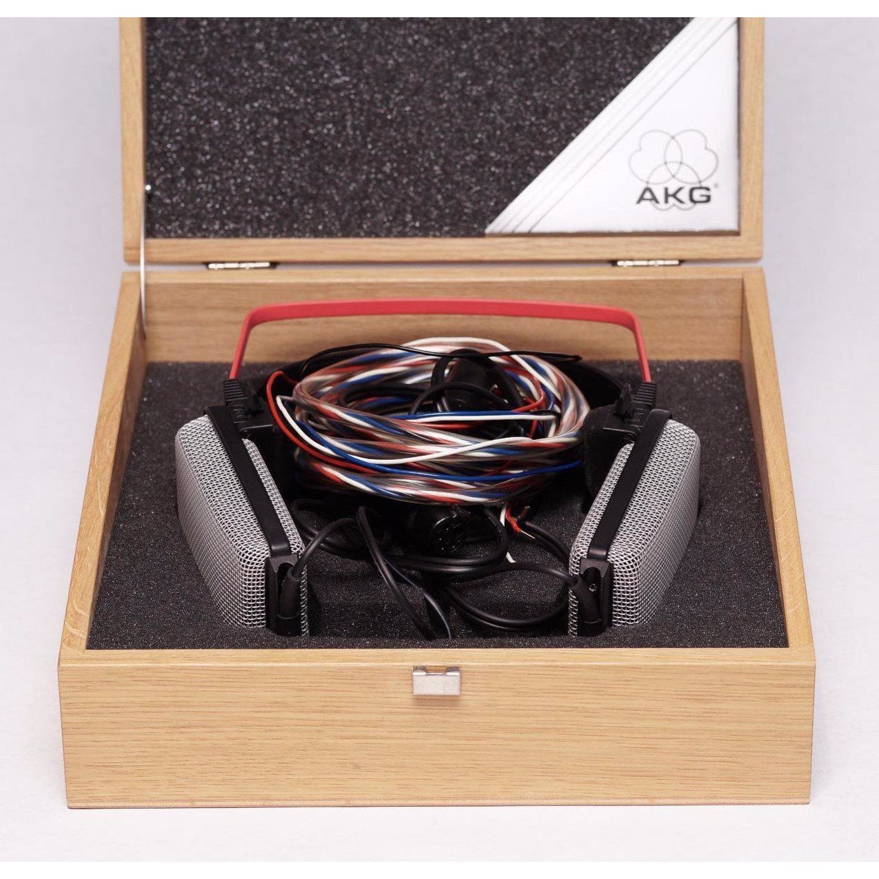 AKG K1000 headphones with original wooden storage box and coiled multicolor cable inside on white background