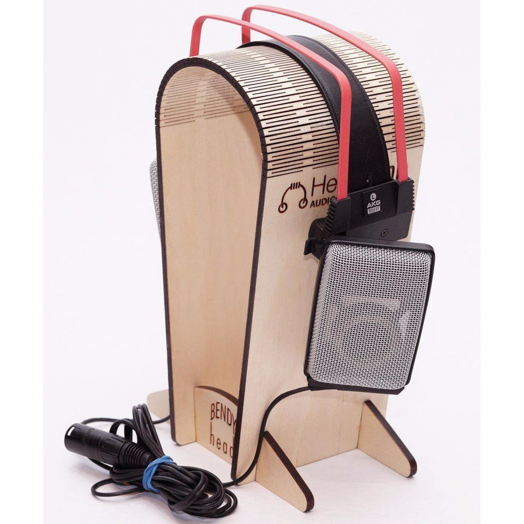 AKG K1000 headphones with mesh ear cups and red headband displayed on a wooden headphone stand with coiled cable