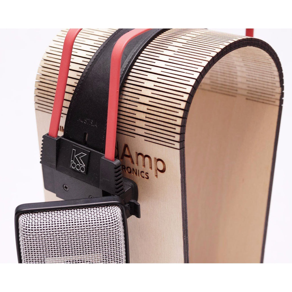 Close-up of AKG K1000 dynamic open back headphones with black headband and red wires on wooden stand