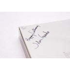 Corner of original Grado HF-1 Limited Edition Headphone box with handwritten message and signature on white surface
