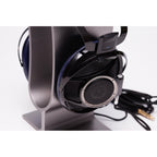 Sony Qualia 010 Reference Headphone with black and blue ear cups on a silver headphone stand with attached cable