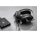 Meze Empyrean open-back planar magnetic headphones connected to a black audio amplifier on a gray surface