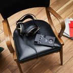 Chord 2Go Wireless Streamer placed on black chair seat with wired headphones and wooden armrests nearby