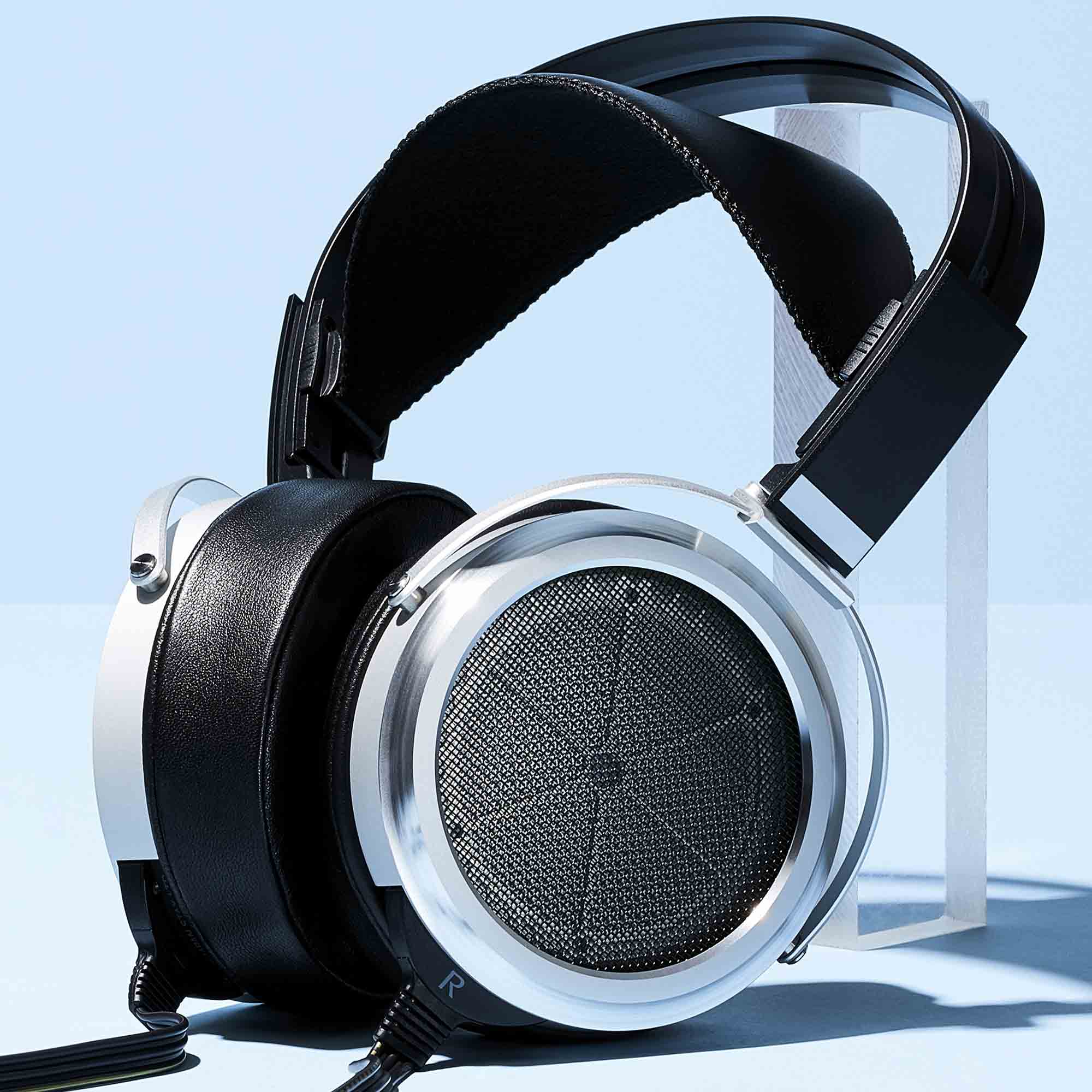 STAX SR-009 Open-Back Electrostatic Headphones with silver ear cups and black leather headband on clear stand